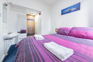 a bedroom with a pink bed and a sink at Pax Lodge in London