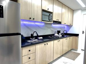 uma cozinha com armários de madeira, um lavatório e um micro-ondas em Apartamento novo decorado com sacada e linda vista da Cidade em São Paulo