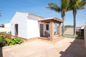 een klein wit huis met een patio en palmbomen bij Casa Juan Solo Familias in Cádiz