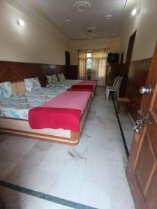 デヘラードゥーンにあるHotel Rajpal Guest Houseのベッドルーム1室(赤毛布付きの大型ベッド1台付)