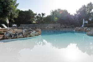 uma grande piscina de água com pedras em Masseria Borgo San Marco em Fasano