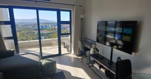 a living room with a flat screen tv and a large window at Cape Town Luxury Stays Knightsbridge Luxury Apartment Century City in Cape Town