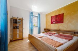 um quarto com uma cama com uma pintura vermelha na parede em Ferienwohnung Walter 
