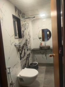 uma casa de banho com um WC, um lavatório e um espelho. em Hotel airport annex em Mumbai