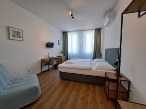 a bedroom with a bed and a chair and a mirror at Hotel Legie in Prague