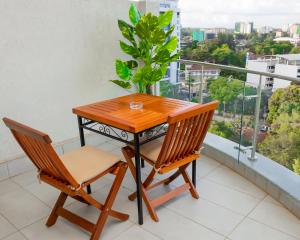 een tafel en twee stoelen op een balkon met een plant bij Capital M - Bednbeyond, Westlands Nairobi, Kenya-Call 25472I95O319 in Nairobi