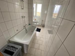 uma casa de banho branca com uma banheira e um chuveiro em 80 m² neues vier Zimmer Apartment 