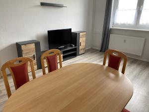 uma sala de jantar com mesa e cadeiras e uma televisão em 80 m² neues vier Zimmer Apartment 
