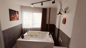baño con bañera blanca y ventana en Grond Konaklama Mersin, en Kapuluören