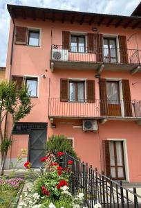 un edificio rosa con balcones y flores en Appartamento 2 poggioli en Cremona