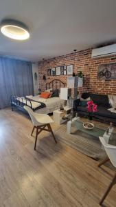 sala de estar con 2 camas y pared de ladrillo en Luceros best studio, en Alicante