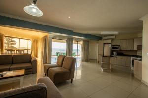 ウヴォンゴ・ビーチにあるSaints View Resort Unit 24のリビングルーム(ソファ、椅子付)、キッチンが備わります。