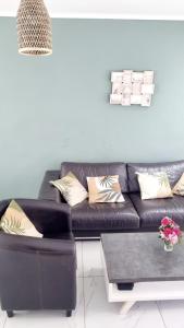 a black leather couch in a living room at Résidence Le Vieux Lyon in Yaoundé