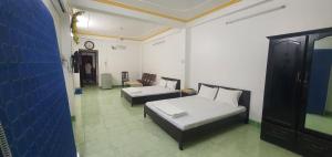 芹苴的住宿－An Bình 66，客房设有两张床、一张沙发和一个时钟。