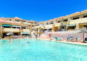 une piscine dans un hôtel avec des gens dans l'eau dans l'établissement PAKITO TENERIFE Mareverde, à Adeje