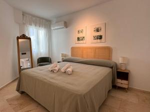two pink pigs sitting on a bed in a bedroom at Apartamento Las Teresas Khalifa in Córdoba