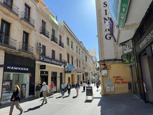 a group of people walking down a street with buildings at Apartamento Las Teresas Khalifa in Córdoba