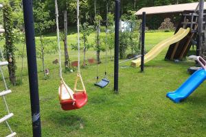 a playground with swings and slides in the grass at Bauernhof Auerhof Ferienwohnung in Aschau im Chiemgau