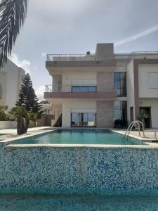 a house with a swimming pool in front of a building at Gorgeous Villa in Salakta Mahdia in Salakta