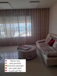 a room with a bed and a couch and a sign at Gorgeous Villa in Salakta Mahdia in Salakta