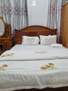 a bed with two white pillows with hearts on it at Khách Sạn Trường Thịnh in Ben Tre