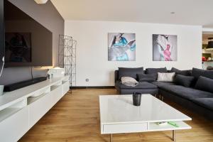 uma sala de estar com um sofá e uma mesa em Maison de ville moderne climatisée avec piscine em Morières-lès-Avignon