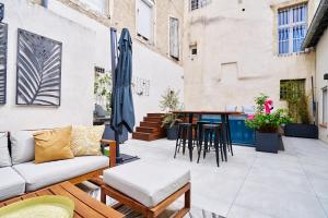 um pátio exterior com um sofá e uma mesa em Maison de ville moderne climatisée avec piscine em Morières-lès-Avignon