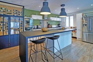 a kitchen with a large island with two bar stools at Maison de ville moderne climatisée avec piscine in Morières-lès-Avignon