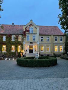 a large house with lights on in a courtyard at Großes Familienapartment mitten in der Natur in Neu Gaarz