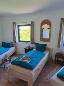a bedroom with two beds and a mirror at Großes Familienapartment mitten in der Natur in Neu Gaarz