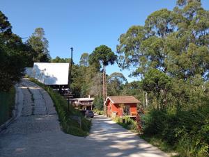 a road with a building on the side of it at Chalé de Vidro Capivari in Campos do Jordão