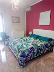 a bedroom with a bed and a pink wall at Alice's Home & House - ospiti come a casa in Statte