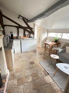 eine Küche und ein Wohnzimmer mit einem Sofa und einem Tisch in der Unterkunft La tour de l Horloge, appt typique à 500m du château in Chinon
