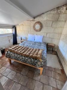 ein Schlafzimmer mit einem großen Bett in einer Steinmauer in der Unterkunft La tour de l Horloge, appt typique à 500m du château in Chinon