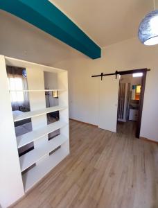 a living room with white shelves and a wooden floor at RoofTop Home Stagnone in Marsala