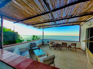 patio ze stołami i krzesłami oraz widokiem na ocean w obiekcie Relais Amalfi Coast w mieście Conca dei Marini