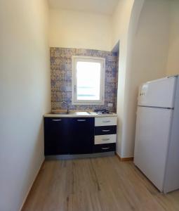 a kitchen with a sink and a white refrigerator at RoofTop Home Stagnone in Marsala +9 photos