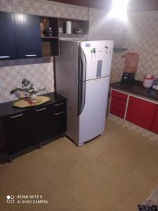 a kitchen with a refrigerator and red cabinets at Chalé de Vidro Capivari in Campos do Jordão