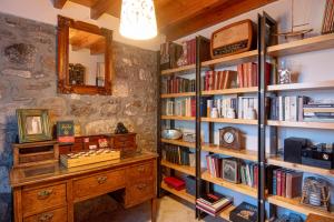 a room with a desk and book shelves with books at ΑΝeΜΙ in Anemótia