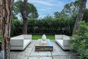 two white couches and a statue in a yard at Catullo 18 Apartment, Garda Lake, Jacuzzi, Fitness, Ac in Desenzano del Garda +17 photos