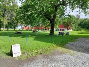 a park with a tree and a sign in the grass at Tjøtta Gjestegaard in Alstahaug