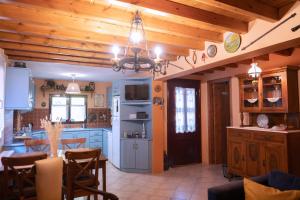 a kitchen with wooden ceilings and a kitchen with a table at ΑΝeΜΙ in Anemótia