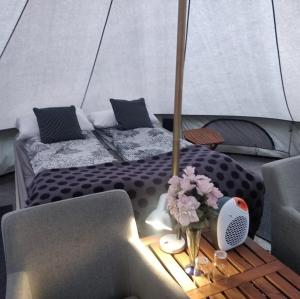 a bedroom with a bed and a table with flowers at Godaland Glamping in Hvolsvöllur