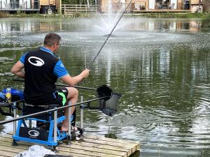 un uomo seduto su una barca che pesca in acqua di Cedar Boutique Lodge-dog fishing and Spa access a York Altre 27 foto