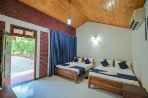 a bedroom with two beds and a window at Yatinuwara Bungalow in Anuradhapura