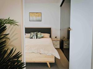 Skyone Lux 2Bed room Aprt in BoxHill with car park في بوكسهل: غرفة نوم مع سرير وزرع الفخار