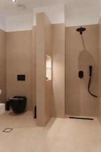 a bathroom with a black toilet and a shower at Limanaki Hotel in Lassi