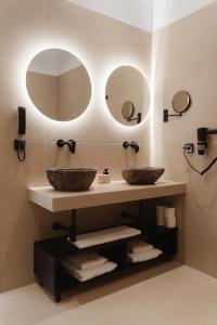 two sinks in a bathroom with two mirrors at Limanaki Hotel in Lassi