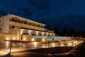 un edificio con luces delante de él por la noche en Limanaki Hotel, en Lassi