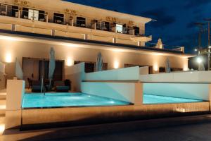 uma villa com piscina à noite em Limanaki Hotel em Lassi
